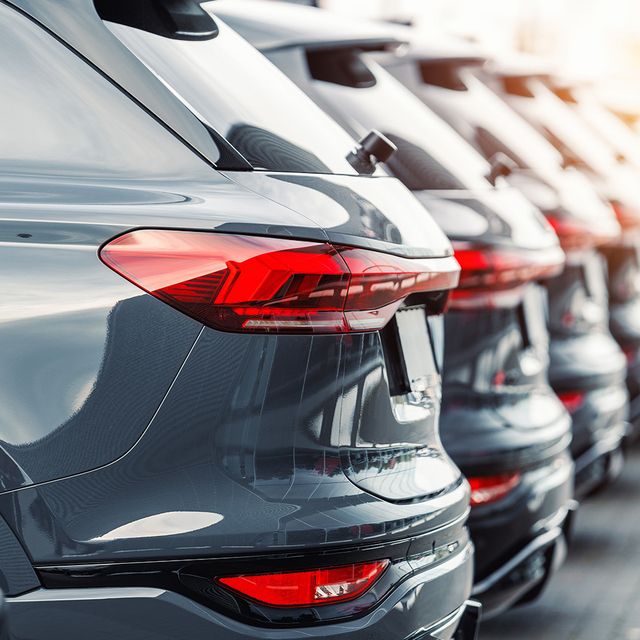 Eine Reihe eleganter grauer SUVs stand dicht nebeneinander geparkt und hob sich durch ihre modernen Rückleuchten und polierten Karosserien hervor.